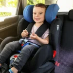 Bambino seduto su seggiolino auto omologato in auto familiare