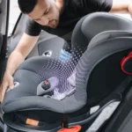 Famiglia con bambini che sistema il seggiolino auto su un’auto familiare spaziosa